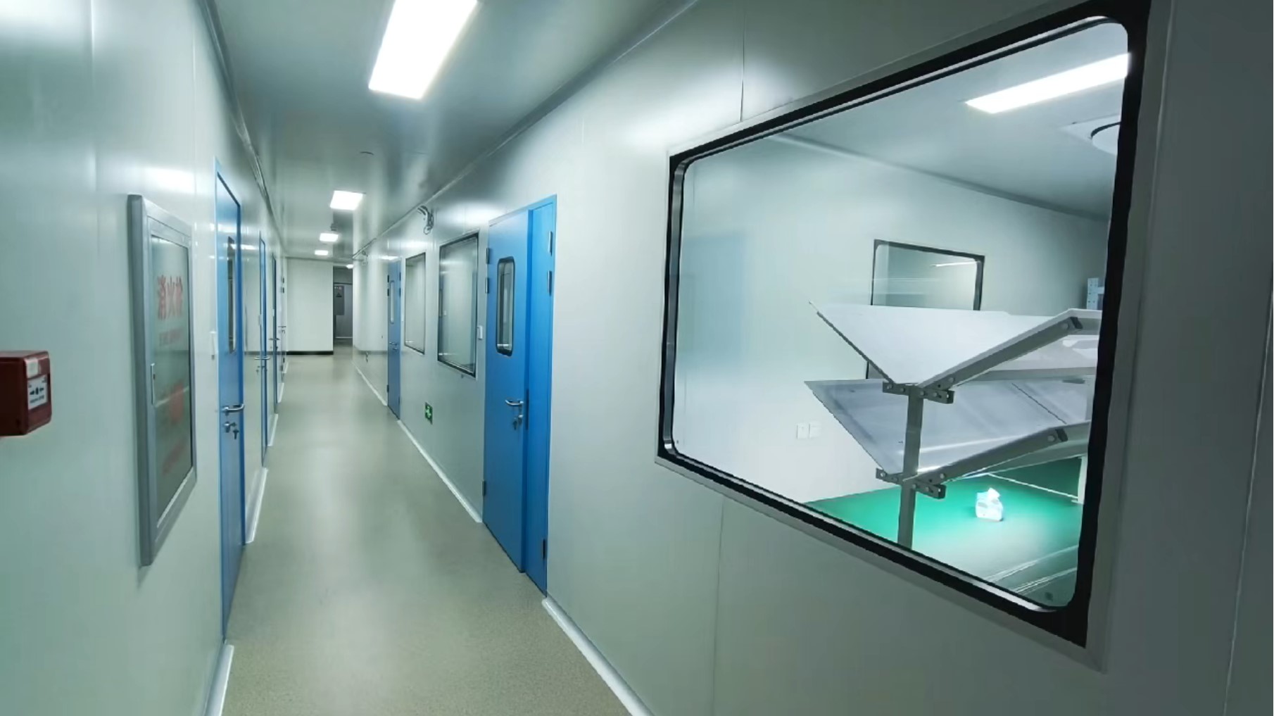 Technicians assembling medical laser fibers at a stainless-steel bench inside the Medfibers cleanroom
            workshop